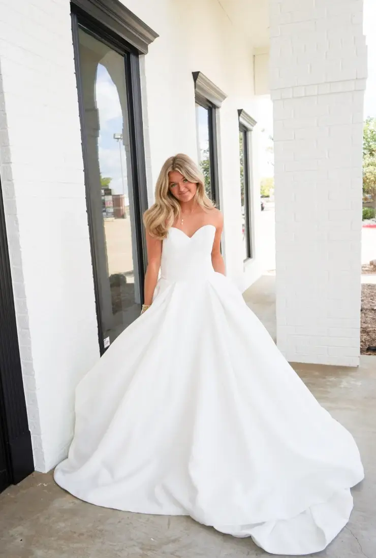 model is wearing a strapless a-line wedding dress